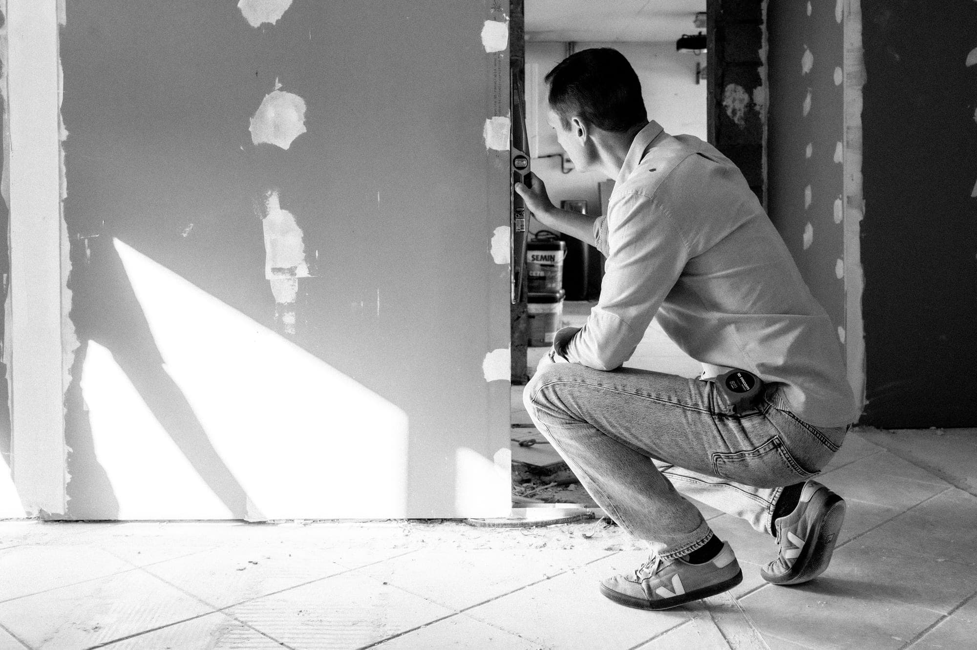Jérôme Pollet contrôle l’aplomb d’une ouverture au niveau, sur un chantier de rénovation
